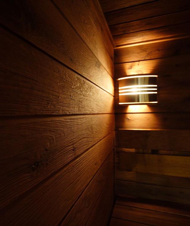 Специальный светильник на деревянной стене сауны