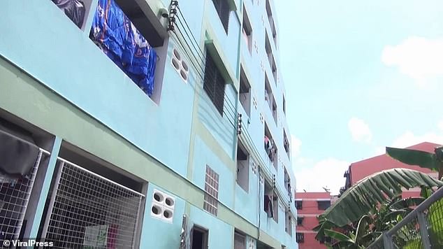 The baby, believed to be a few days old, was heard crying by residents at the apartment block (pictured) in Samut Prakan, central Thailand, on Monday at 10.30am