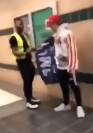 The incident occurred in the hallways at Edmond Santa Fe High School, north of Oklahoma City, on Monday when the student in the yellow vest confronted a classmate wearing a MAGA hat and Trump 2020 banner around his shoulders