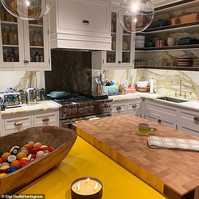 Everything in place: Her inviting kitchen was lit up by large orb light fixtures and had a sizable oven range, plenty of cabinets with chicken wire panels and intriguing uncovered shelves