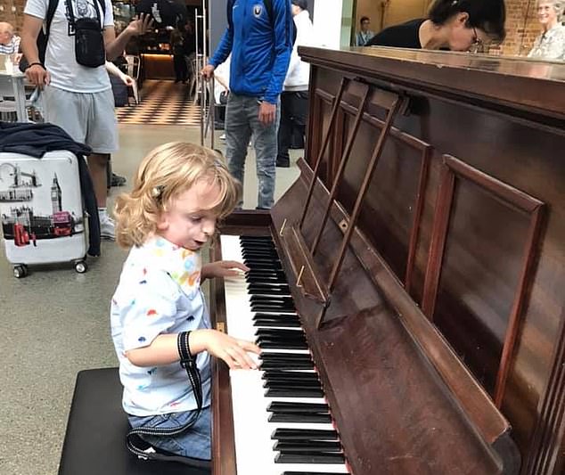 The four-year-old (pictured playing the piano at St Pancras International Station) has a tracheostomy- a tube inserted into his neck- due to his small upper jaw and upper airway which causes severe breathing problems