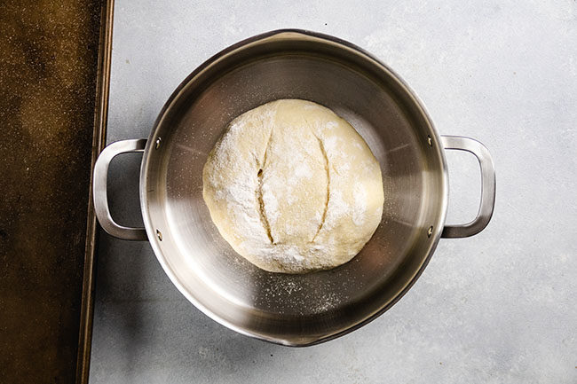 overhead photo of bread dough in a stainless steel pot