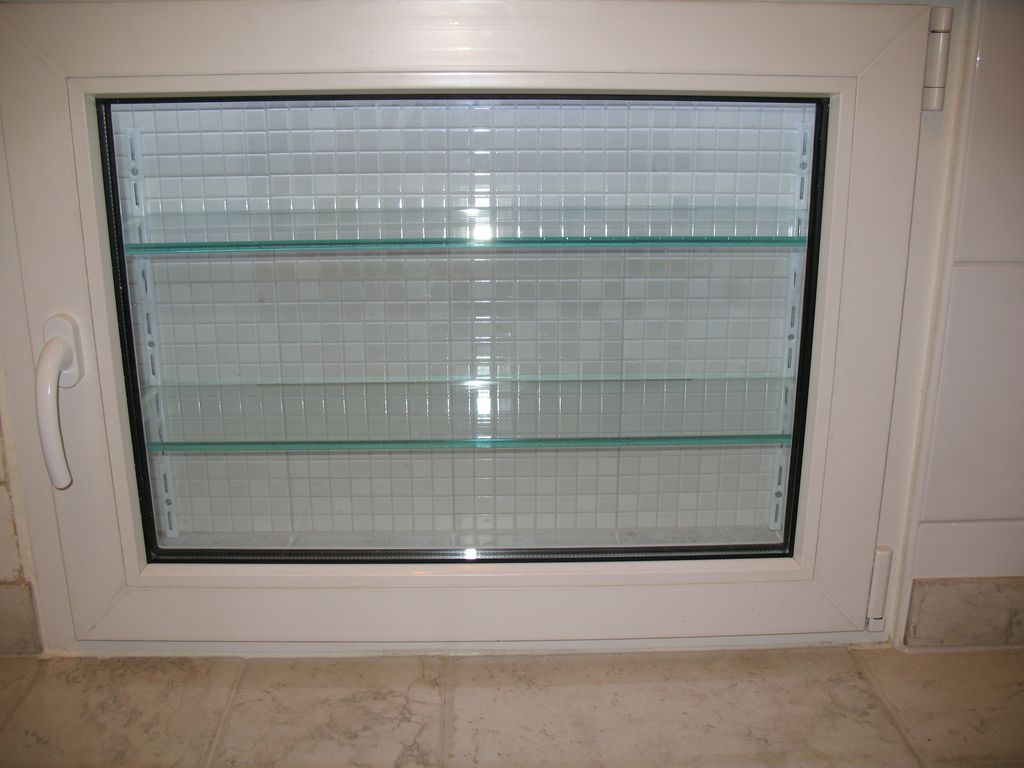 Холодильник под окном со стеклянными полками