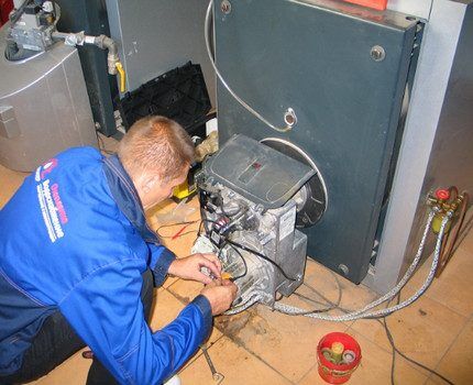 Мастер ремонтирует газовый котел