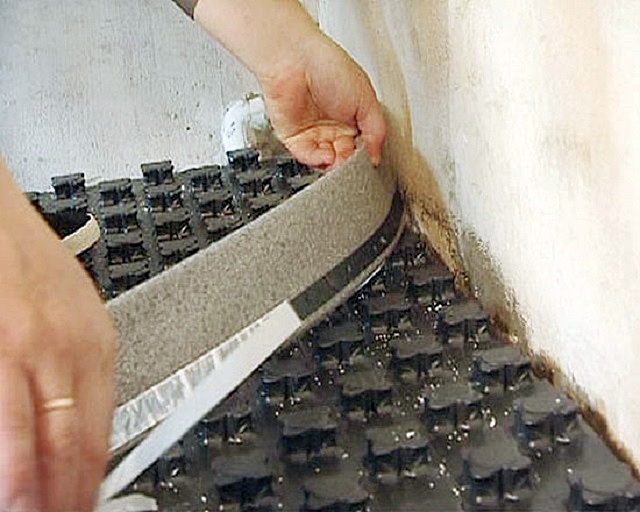Установка демпферной ленты по периметру комнаты между термоизоляционными матами и стенами – для последующей заливки создаваемого «теплого пола» стяжкой.