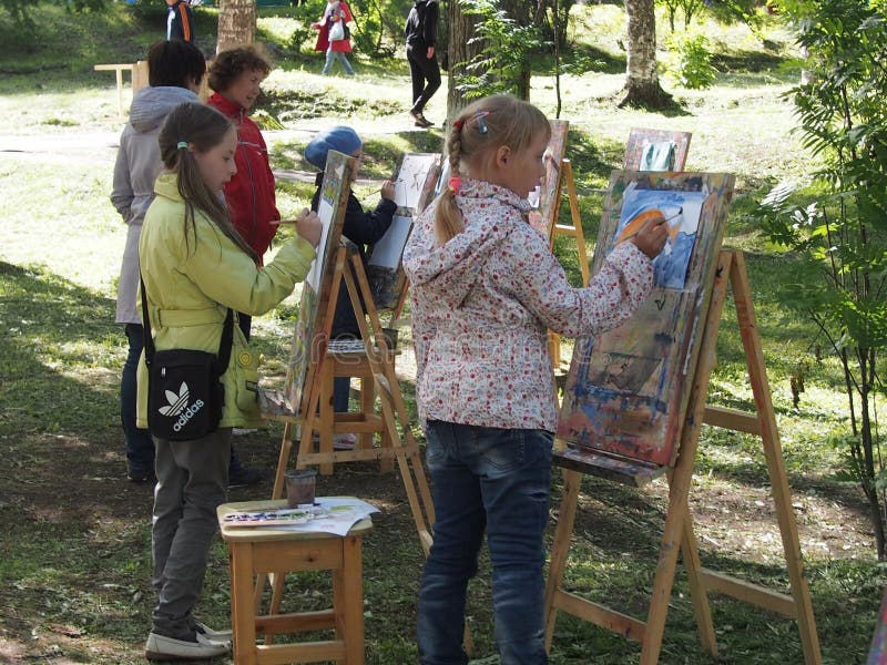 Children drawing on easels outdoor stock images