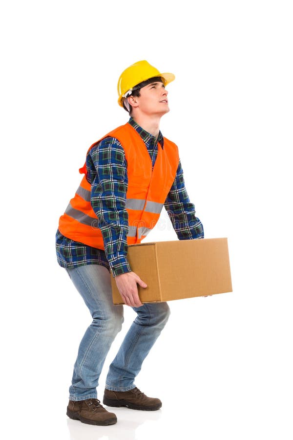 Construction worker picking up heavy box. royalty free stock images