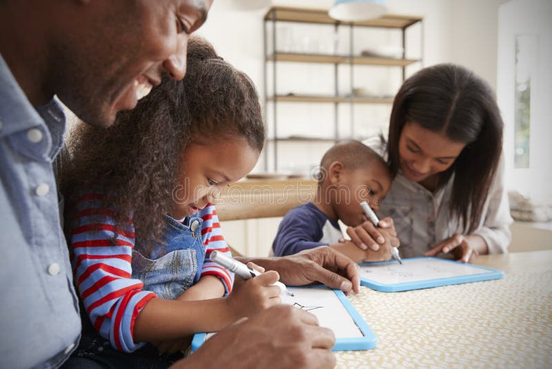 Parents And Children Drawing On Whiteboards At Table stock images