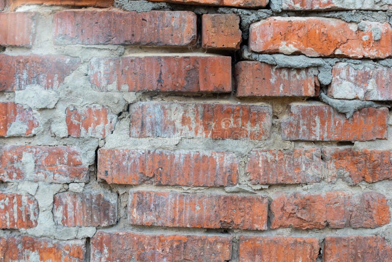 Texture of an old broken red brick wall with cement mortar. Background of clay and silicate brick on broken wall with large cracks.  stock images