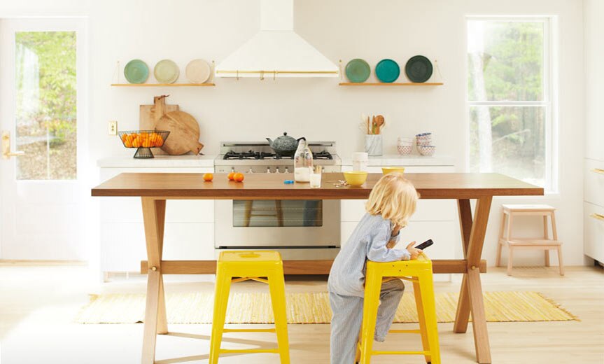 An open, inviting kitchen with neutral walls and bright yellow chairs